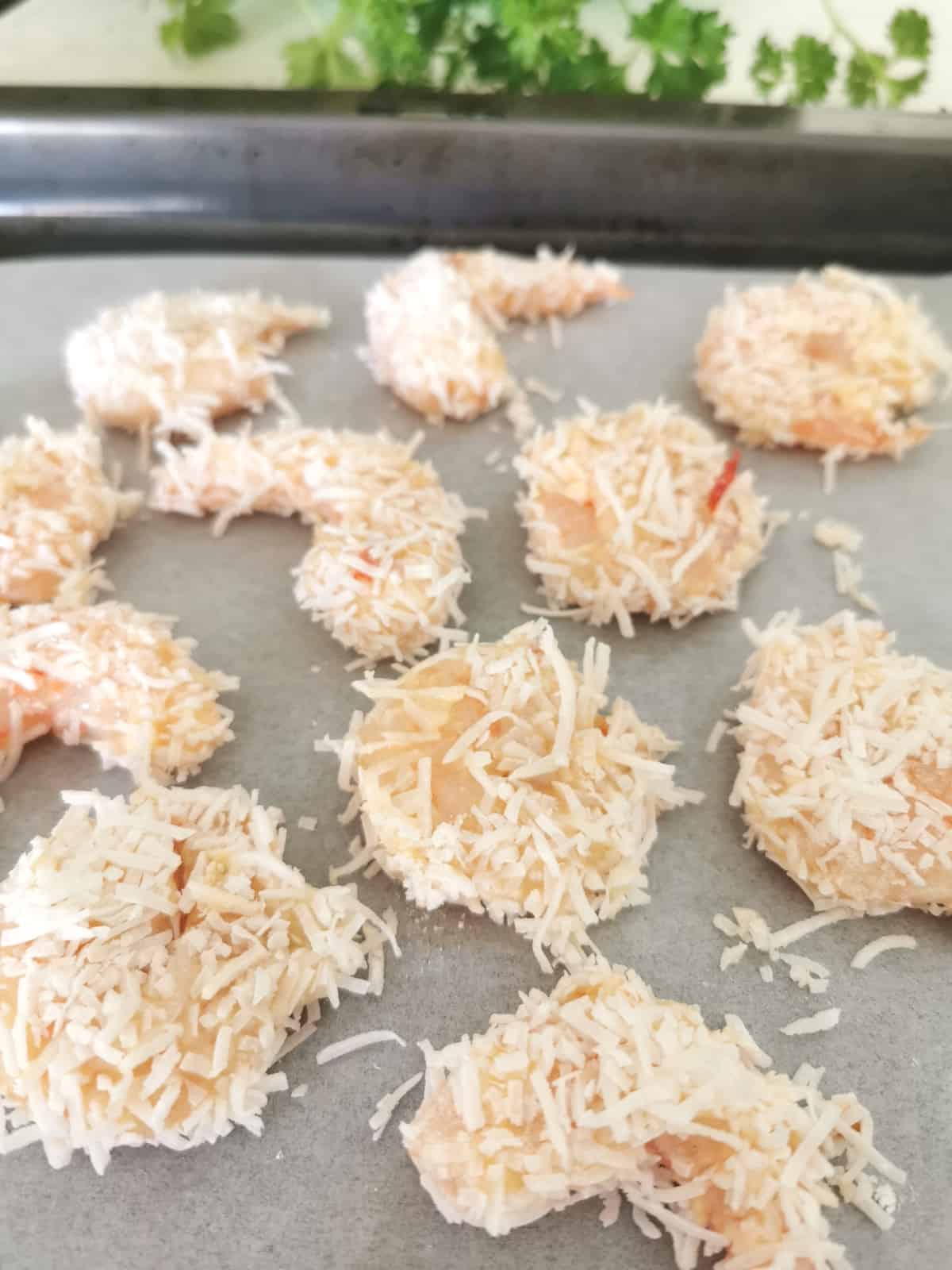 Shrimp are coated in coconut and placed on baking tray