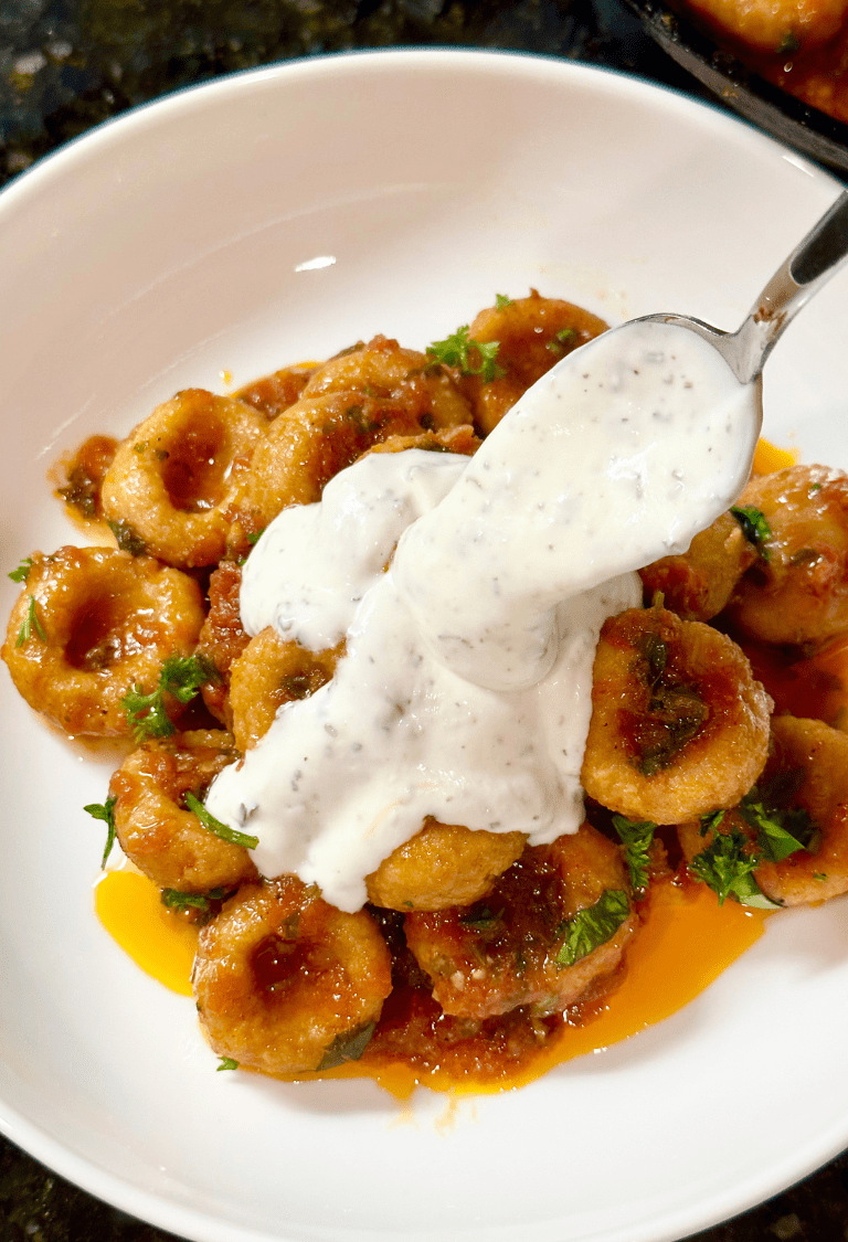 The recipe is served and garnished with spoonful of yogurt dressing.