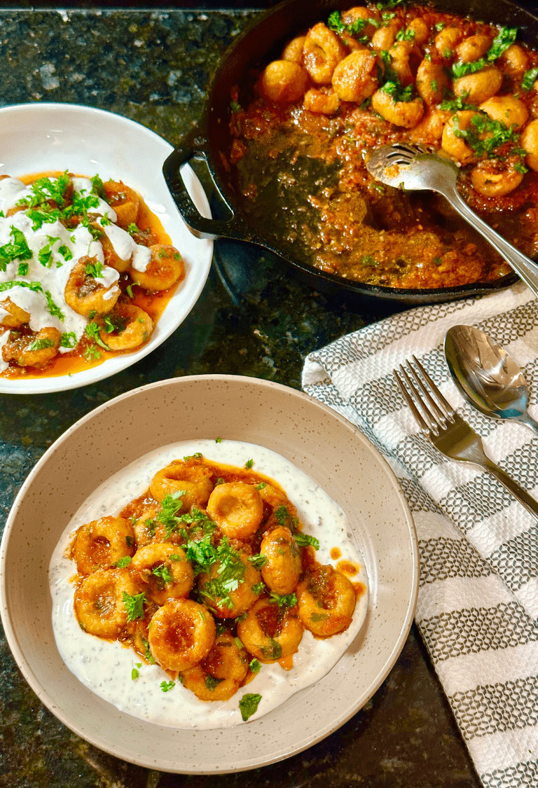 Fellah kofte is served in two plates and garnished with yogurt mixture and chopped fresh parsley and cilantro.