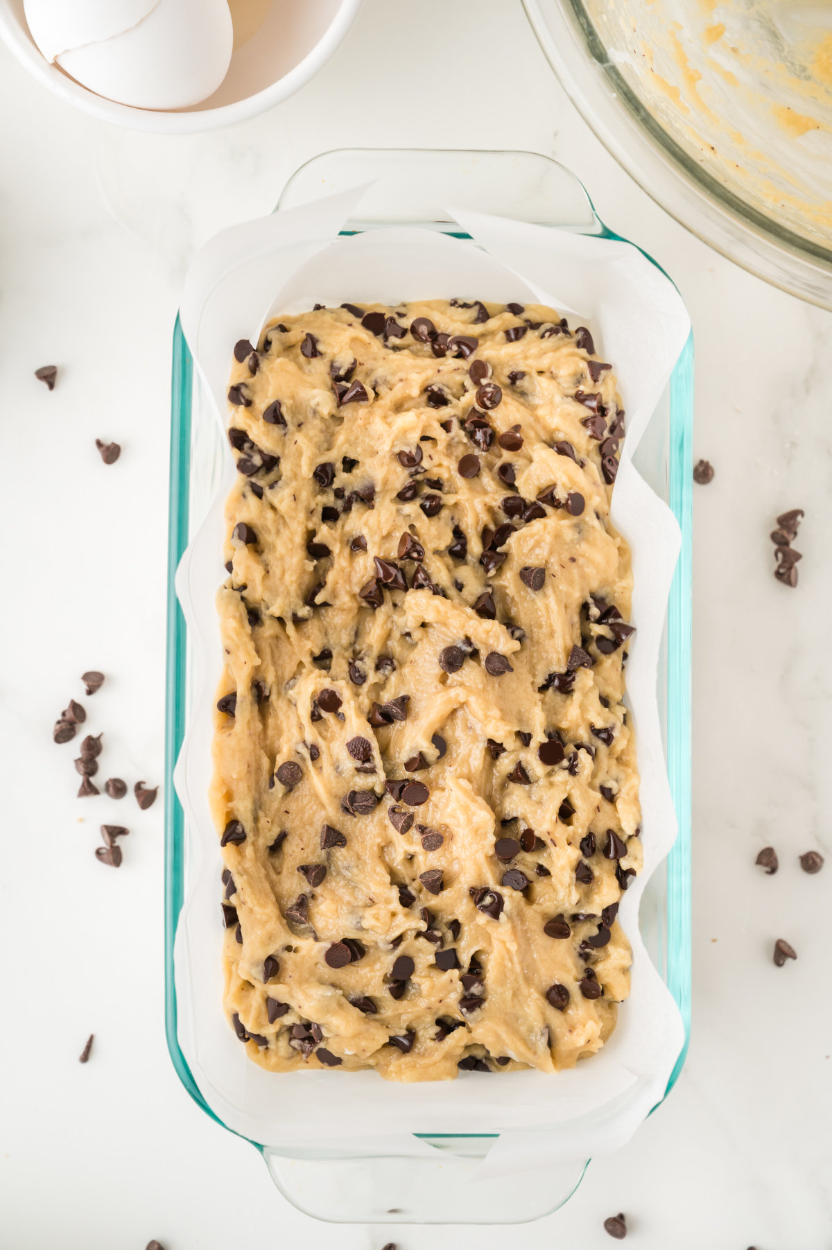 The cake mixture, now in a glass baking tin lined with baking paper.