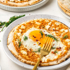 The eggs served on a white dish with a golden fork, viewed from the side.