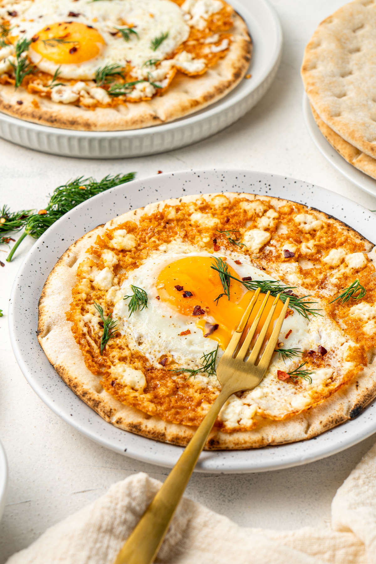 The eggs served on a white dish with a golden fork, viewed from the side.