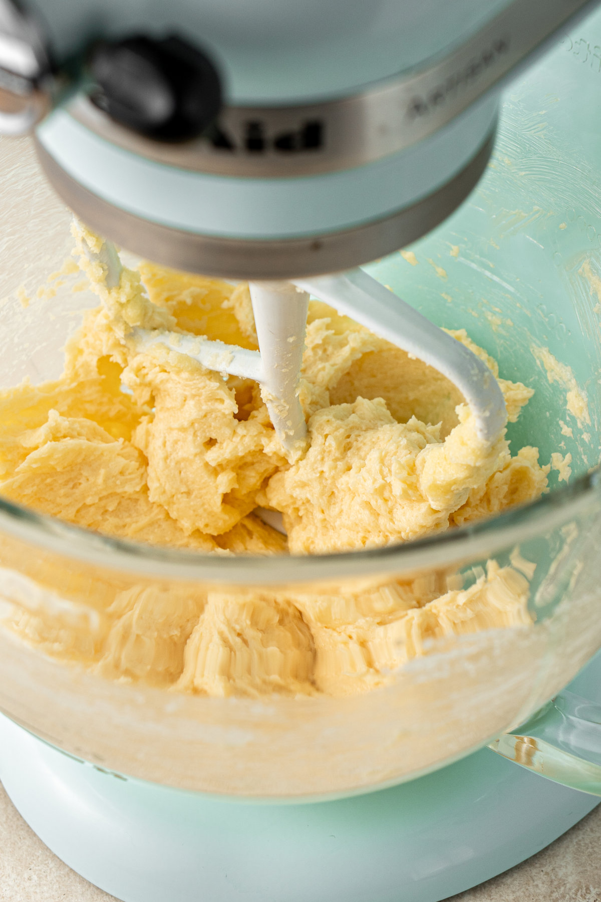 Close up image of the bowl of a stand mixer, with the beginnings of a thick dough in it.