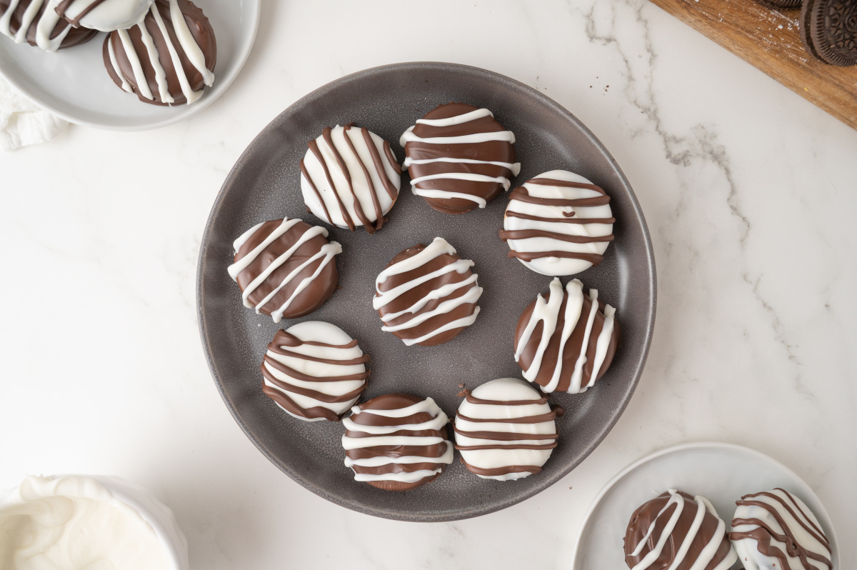 A grey plate on a kitchen counter, with several Oreos on it ready to be eaten.