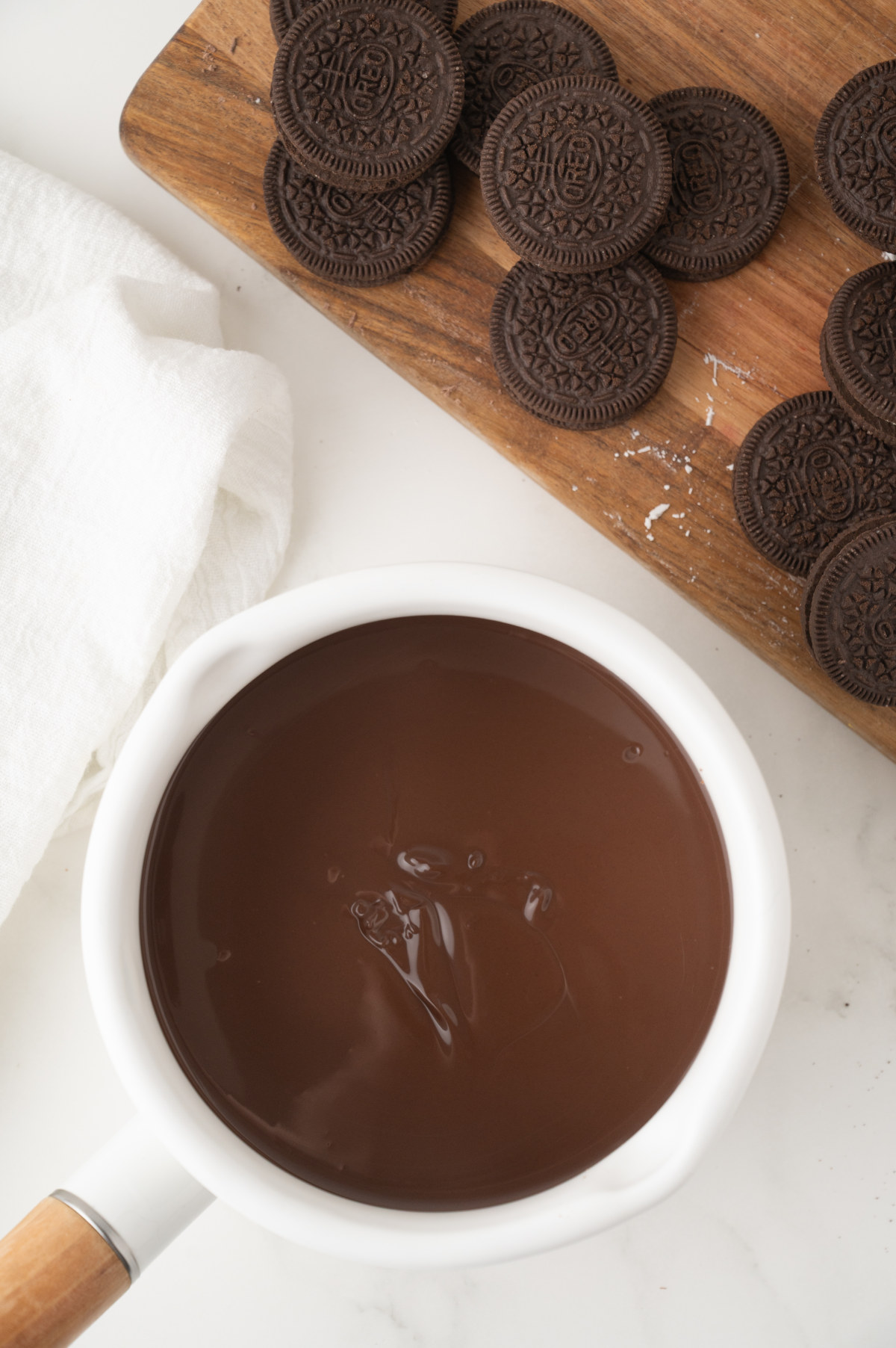 A small white saucepan filled with melted chocolate almond bark.